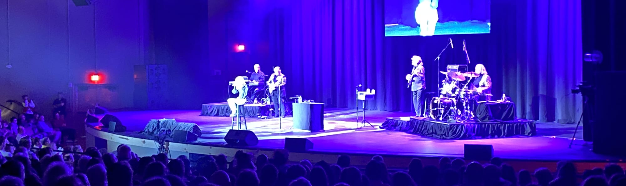 signer on stage in chair washed out by the lights New Orleans